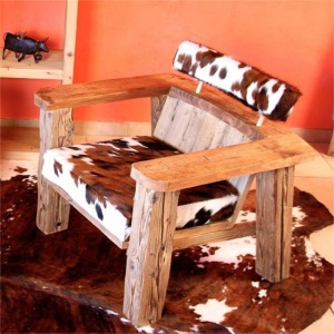Fauteuil de salon "NAP" en vieux bois avec assise et dossier en peau de vâche normande francaise